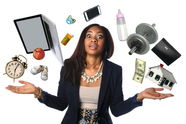 African American businesswoman juggling many objects and feeling overwhelmed